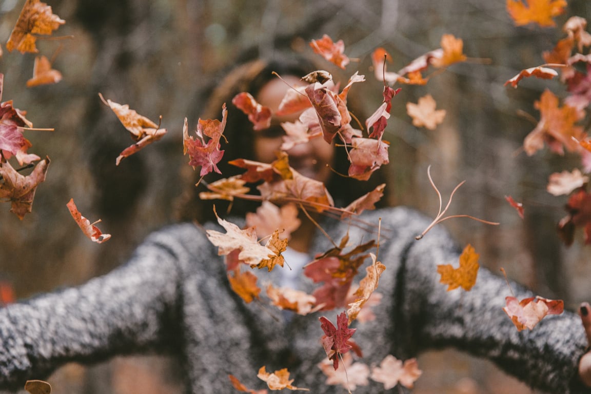 Woman Playing with Autumn Leaves